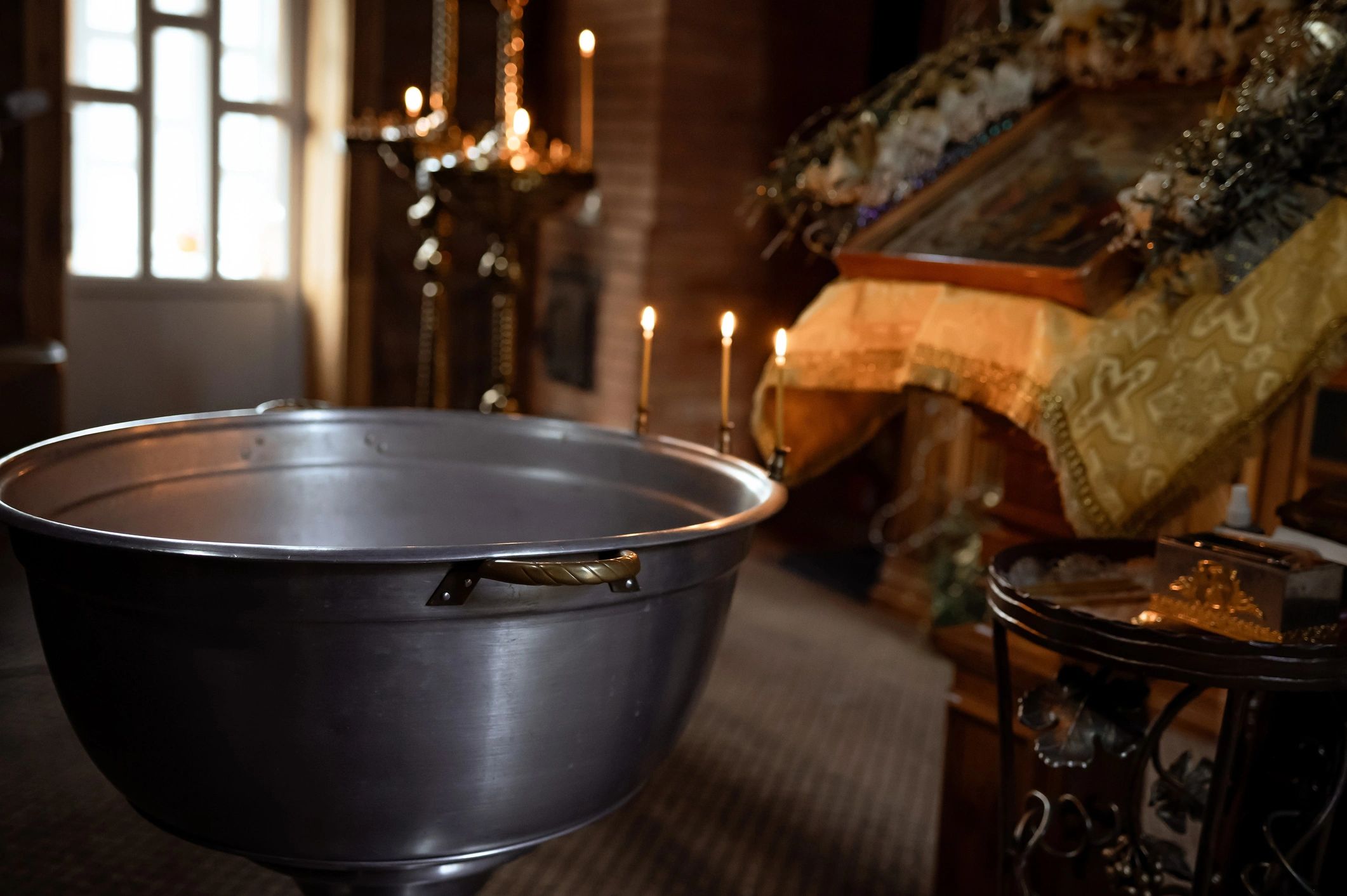 Baptismal font and candles in a church interior